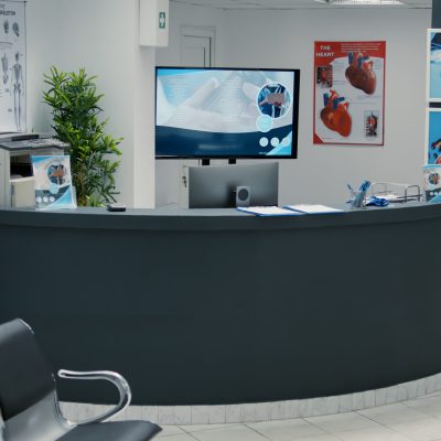 No people in empty waiting area at clinical center with reception desk, waiting room with seats to start checkup visit appointment. Medical examination with doctor at hospital lobby.